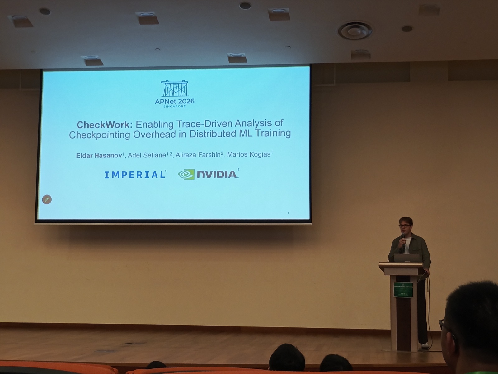 Presenting CheckWork at APNet 2026 in Singapore, title slide on screen with Imperial and NVIDIA affiliations